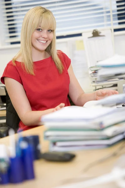 Woman sitting happily at her desk — Stock Photo, Image