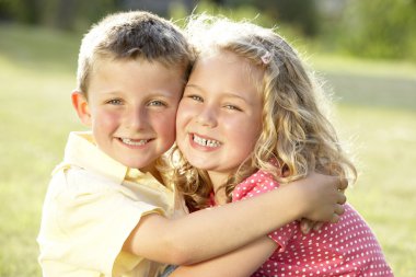 2 Children hugging outdoors clipart