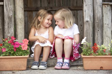 Two Young Girls Playing in Wooden House clipart