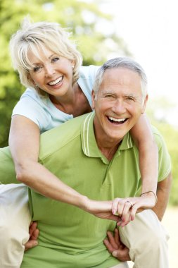 Mature couple having fun in countryside clipart