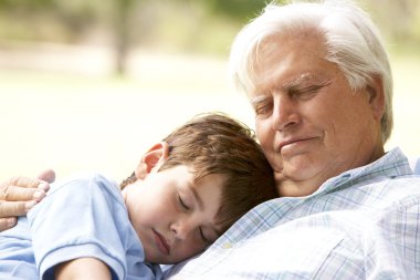 Grandfather And Grandson Taking Nap Together clipart