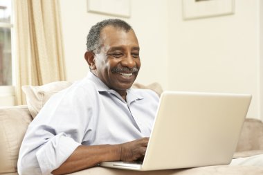 Senior Man Using Laptop At Home clipart