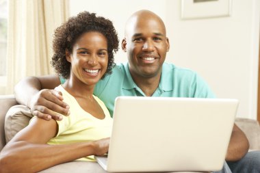 Couple Using Laptop At Home clipart