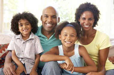 Young Family Relaxing On Sofa At Home clipart