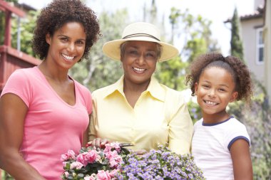 Senior Woman With Adult Daughter And Granddaughter Gardening Tog clipart