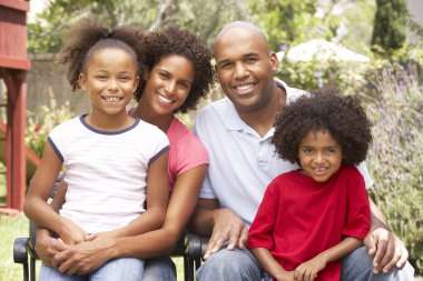 Young Family Relaxing In Garden Together clipart