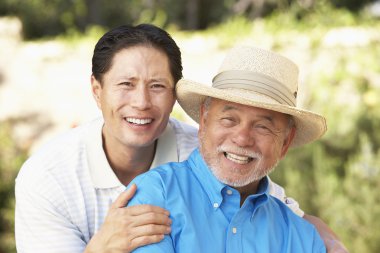 Senior Man With Adult Son In Garden clipart