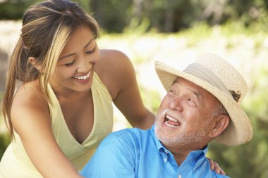 Senior Man With Adult Daughter In Garden clipart