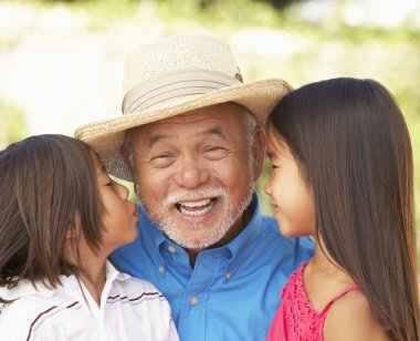 Grandfather With Grandchildren In Garden clipart