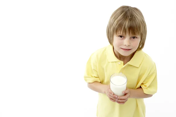 Gülen çocuk tutan bir bardak süt studio portresi — Stok fotoğraf