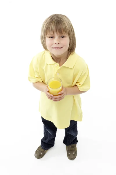 工作室的微笑男孩控股玻璃果汁的肖像 — 图库照片