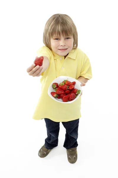 Studio porträtt av leende pojke anläggning skål med jordgubbar — Stockfoto