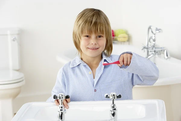 Молодий хлопчик чистить зуби в раковині — стокове фото