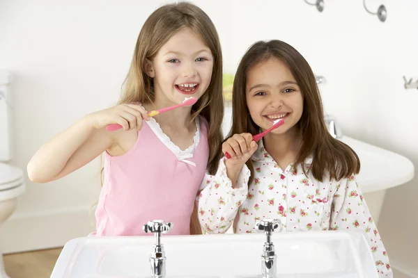 Två unga tjejer borsta tänderna på diskbänken — Stockfoto