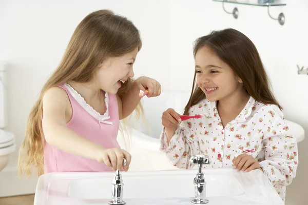 两个年轻女孩在接收器刷牙 — 图库照片