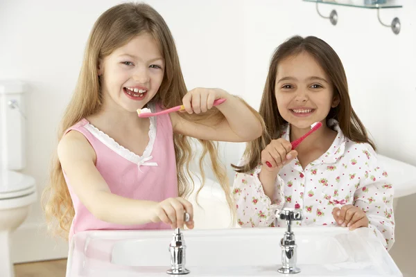 Duas jovens garotas escovando dentes no dissipador — Fotografia de Stock