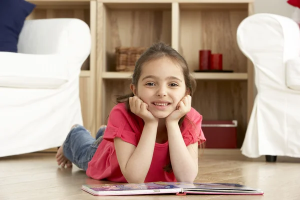 Mladá dívka čtoucí knihu doma — Stock fotografie