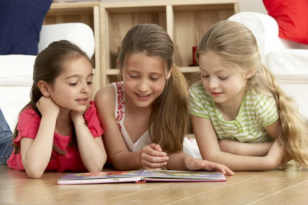 Drie jonge meisjes lezen boek thuis — Stockfoto