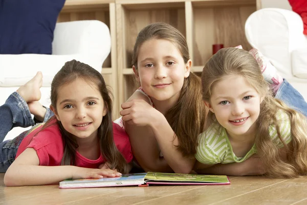 三个年轻的女孩在家里读书 — 图库照片
