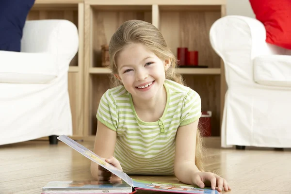 Genç kız evde kitap okurken — Stok fotoğraf