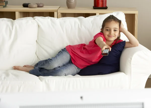 Ung flicka tittar på TV hemma — Stockfoto