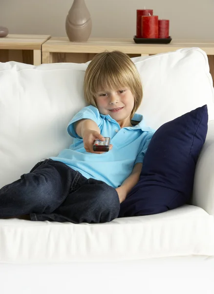 Mladý chlapec sleduje televizi doma — Stock fotografie