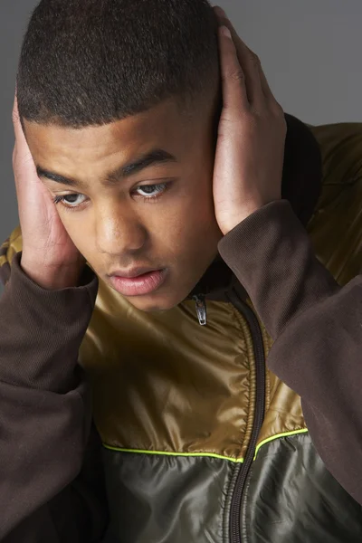Tonårspojke som täcker öronen med händer — Stockfoto