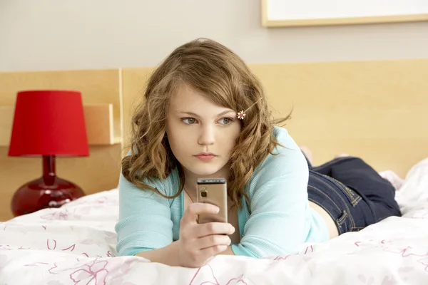 悲伤少女在卧室里用手机 — 图库照片