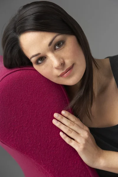 Studioporträt Einer Frau Die Sich Auf Einer Rosafarbenen Chaiselongue Entspannt — Stockfoto