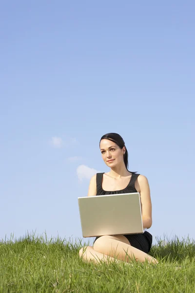 Frau nutzt Laptop im Freien in sommerlicher Landschaft — Stockfoto