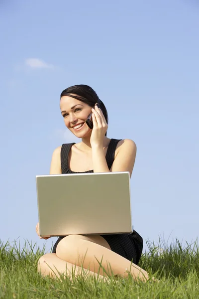 Kvinna med laptop och mobiltelefon utomhus i landskapet — Stockfoto