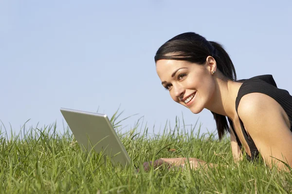 Vrouw met laptop buiten in zomer platteland — Stockfoto