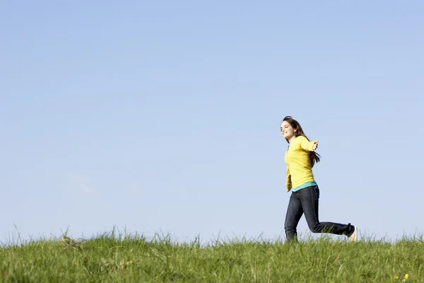 Dospívající dívka prochází letní louka夏の草原を通じて実行している 10 代の少女 — ストック写真