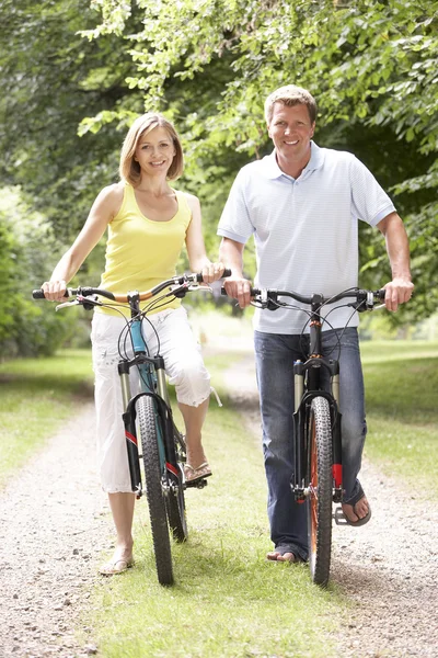 Couple riding bikes in countryside — Stock Photo, Image