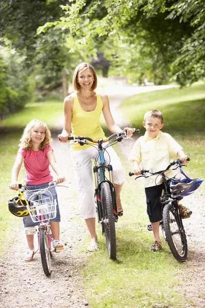Mãe e crianças andando de bicicleta no campo — Fotografia de Stock