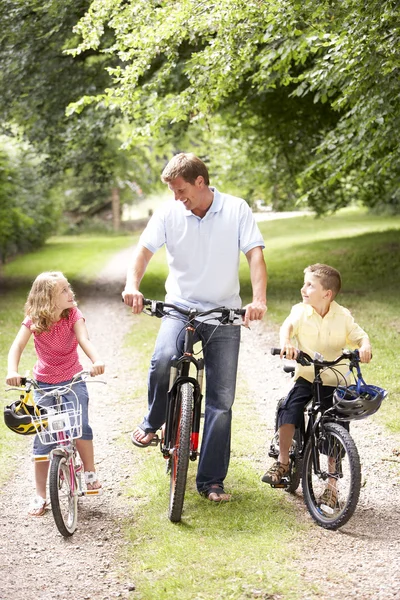 Ojciec i dzieci na rowerach w okolicy — Zdjęcie stockowe