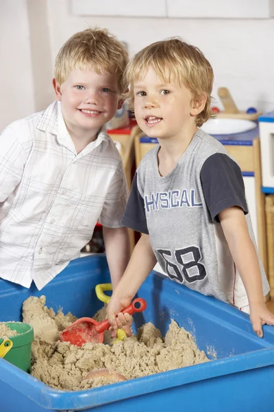 在沙坑里玩在一起的两个年轻男孩 — 图库照片