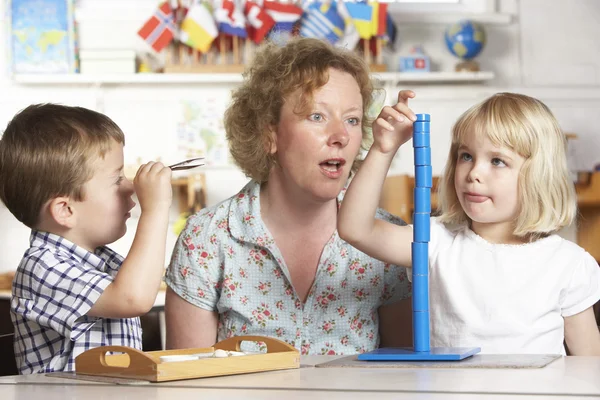 Ενηλίκων, βοηθώντας τα δύο μικρά παιδιά στο Montessori/προ-προσχολικής — Φωτογραφία Αρχείου