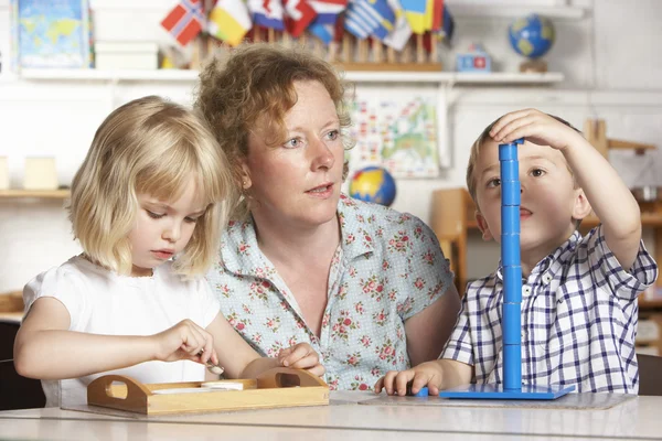 Ενηλίκων Βοηθώντας Δύο Μικρά Παιδιά Στο Montessori Προ Προσχολικής — Φωτογραφία Αρχείου