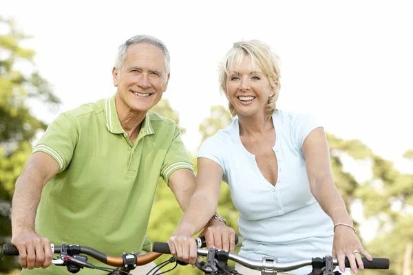 Mature couple riding bikes — Stock Photo, Image