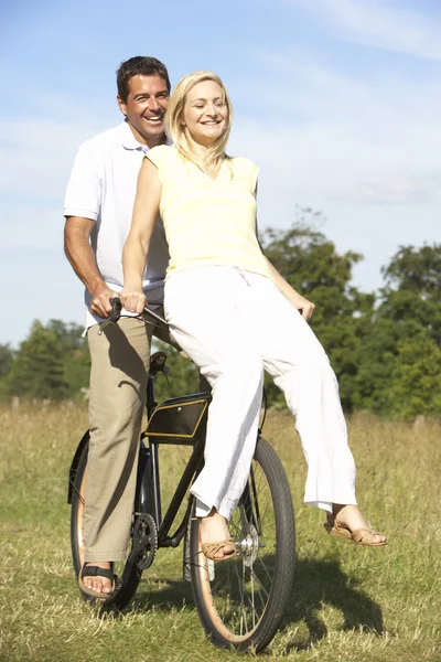 若いカップルの田園地帯で自転車に乗る — ストック写真