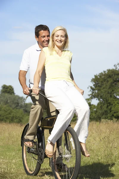 Jovem casal andar de bicicleta no campo — Fotografia de Stock