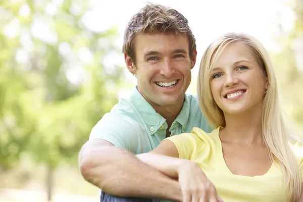 Portrait Of Young Couple Sitting In Park — Stock Photo, Image