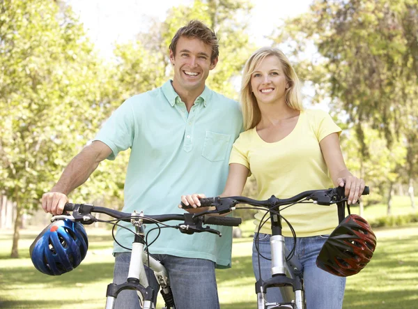Ungt par på cykel rida i park — Stockfoto
