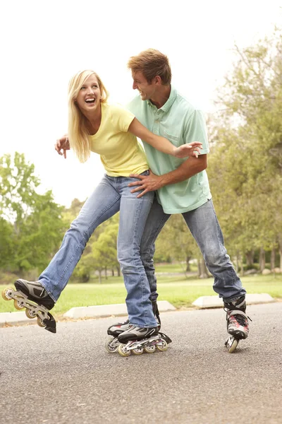 パークでスケート ラインで身に着けているカップル — ストック写真