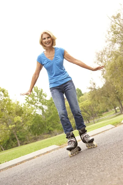 Senior mulher patinação no parque — Fotografia de Stock
