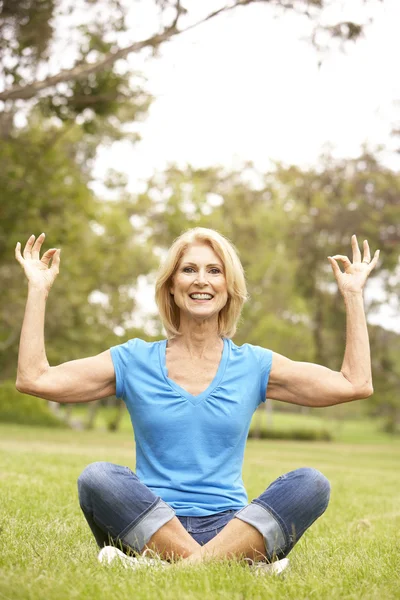 Mulher sênior fazendo Yoga no parque — Fotografia de Stock