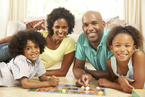 Família jogando jogo de tabuleiro em casa — Fotografia de Stock