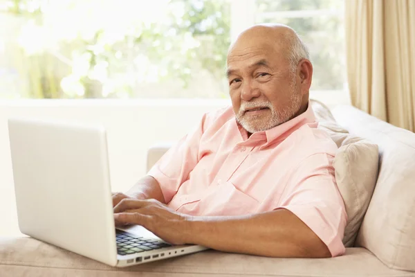 Пожилой Мужчина Пользуется Ноутбуком Дома — стоковое фото