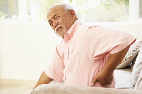 Homem Sênior sofrendo de dor nas costas em casa — Fotografia de Stock